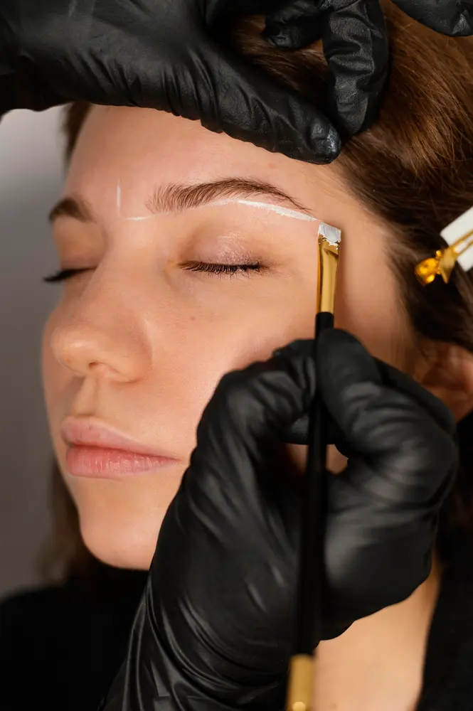 woman-getting-eyebrow-treatment-from-beautician
